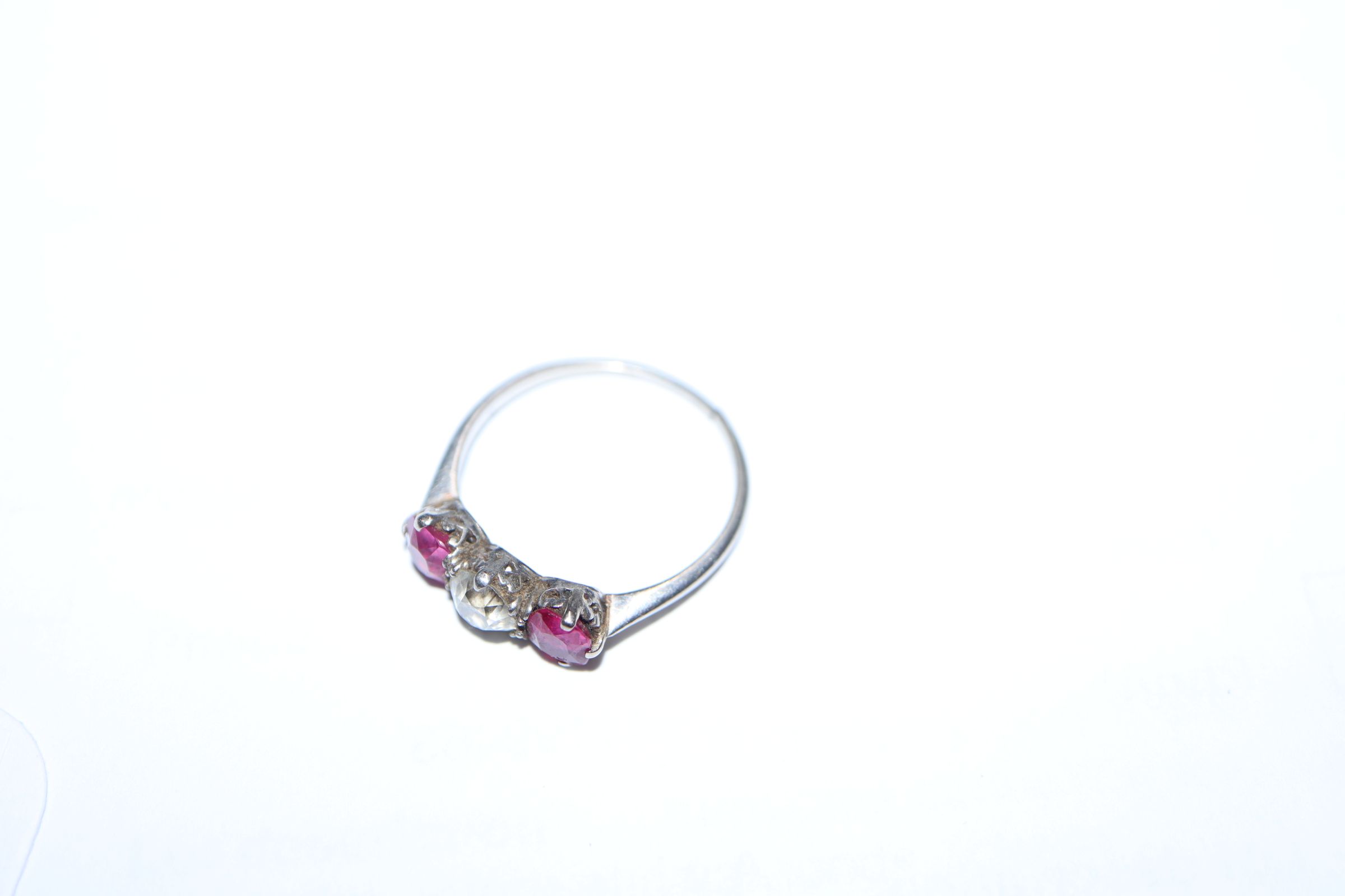 A white metal, ruby and diamond three stone ring, (shank cut). - Image 6 of 7
