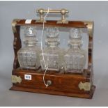 A late Victorian plated mounted oak tantalus, with three decanters