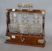 A late Victorian plated mounted oak tantalus, with three decanters