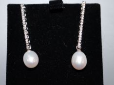 A pair of 750 white metal, diamond and cultured pearl line drop earrings, 35mm.