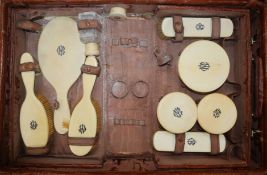 An Edwardian crocodile skin travelling toilet case, fitted with ivory accessories