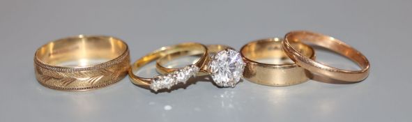Three 9ct gold wedding bands, a diamond four-stone ring and another solitaire ring.