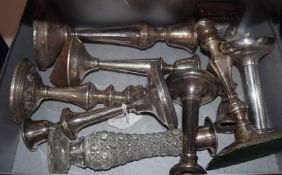 Nine assorted silver or white metal single candlesticks, of varying sizes.