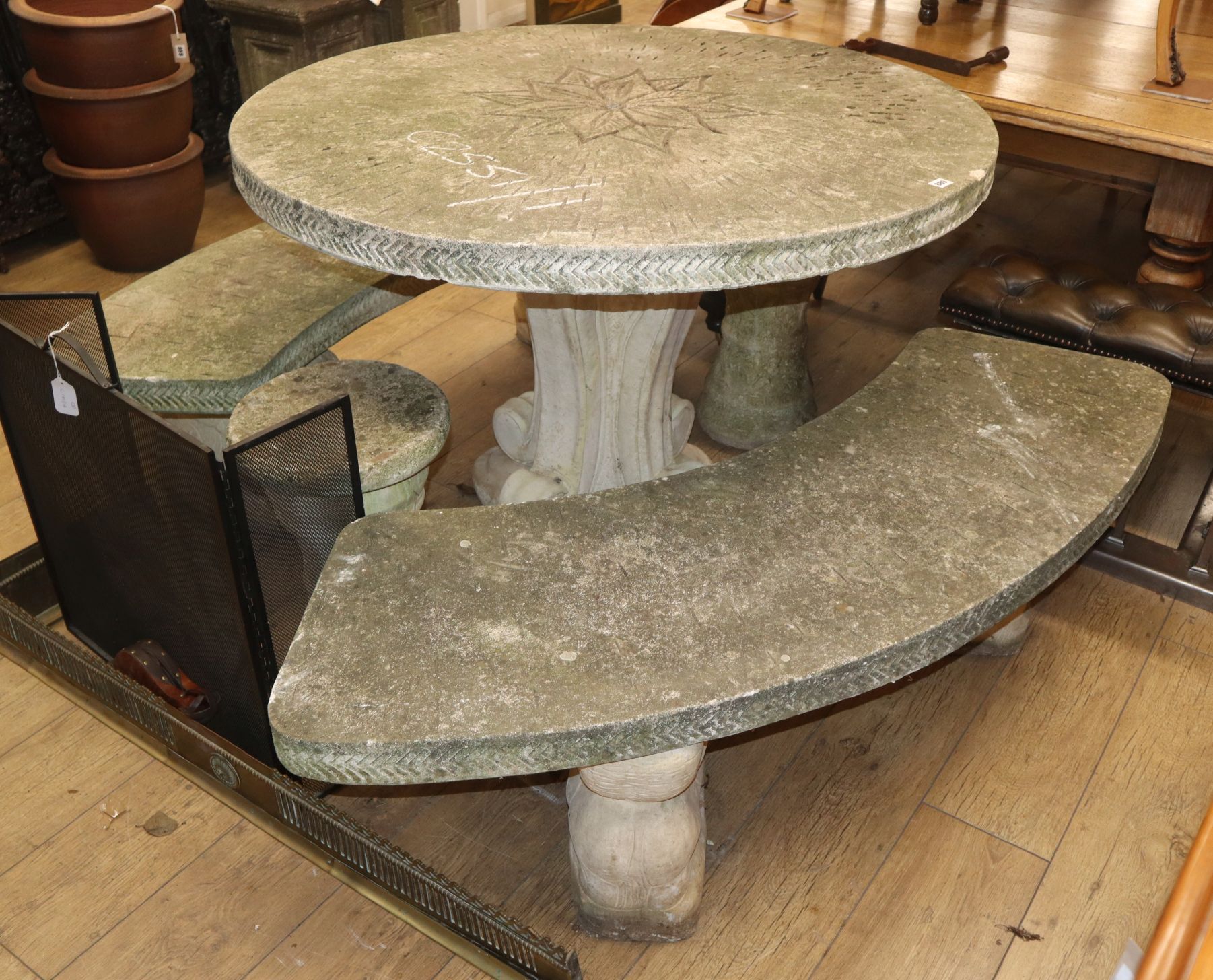 A reconsituted stone circular garden table and two carved seats and two stools Table diameter 115cm
