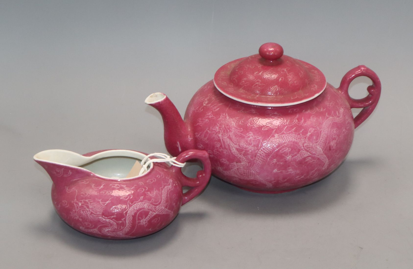 A Chinese ruby ground sgraffito 'dragon' teapot and milk jug , Republic period