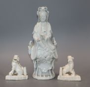 A Chinese blanc de chine figure of Guanyin and a pair of lion dog joss-stick holders, faults