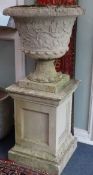 A pair of reconstituted stone campana shaped gardens urns, on plinth H.134cm