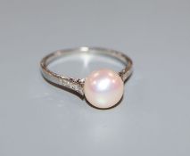 A cultured pearl, diamond and white metal (stamped 'platinum') ring, the single pearl in fancy