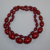 A single strand graduated simulated cherry amber necklace, gross weight, 114 grams, 82cm.