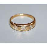 An 18ct. gold three stone gypsy set diamond ring, size N/O.