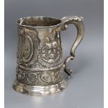 A late George II silver mug, with later embossed decoration, London, 1757 (a.f.), 12.9cm, 14.5 oz.