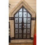 A Gothic style wrought iron framed window with heavy reconstituted stone frame H.160cm