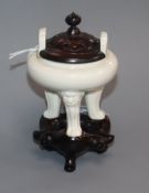 A Chinese small blanc de chine tripod censer, 17th century, wood cover and stand, repaired handle