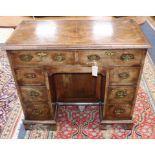 An early 20th century Queen Anne style walnut kneehole desk W.88cm