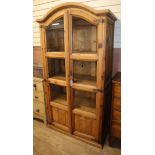 A pine two door glazed cabinet with arched top, H.195cm
