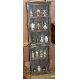 A distressed hardwood two door glazed wall mounted cabinet, together with a collection of 17