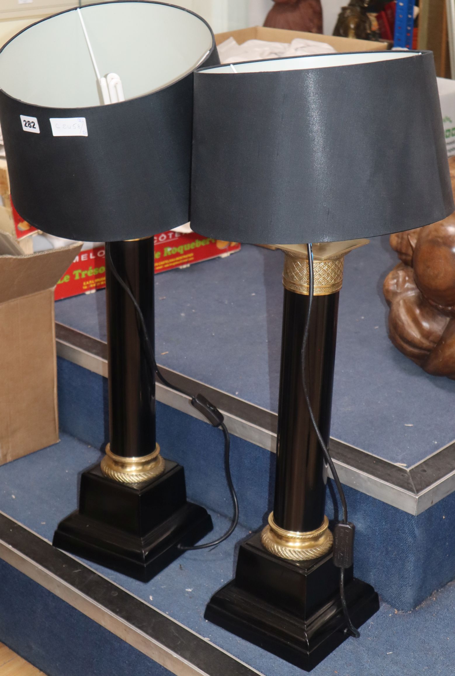 A pair of gilt metal mounted ebonised table lamps on square plinth base