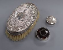 An embossed white metal clothes brush and two silver pill boxes (one a.f.).