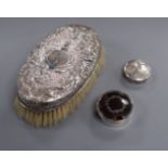 An embossed white metal clothes brush and two silver pill boxes (one a.f.).