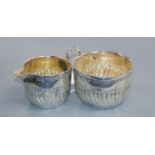 A late Victorian silver wrythen fluted cream jug and sugar bowl, Sheffield, 1890, 112 grams.