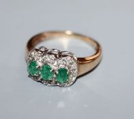 A 9ct gold, three stone emerald and diamond cluster ring, size O.