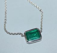 An 18ct white gold and solitaire emerald set pendant necklace, pendant 9mm.
