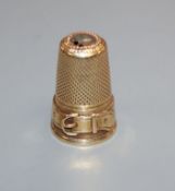 A yellow metal thimble with buckle decoration, gross 6 grams, 25mm..