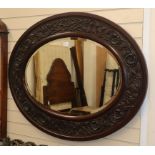A large Victorian carved mahogany oval mirror W.126cm