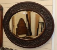 A large Victorian carved mahogany oval mirror W.126cm