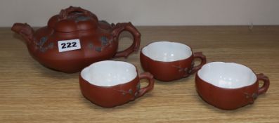 A Yixing pottery teapot and three cups Provenance - The owner and her family lived in Singapore in