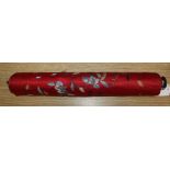 A Chinese red silk banner embroidered with figures, flowers, insects and calligraphy, on brass-