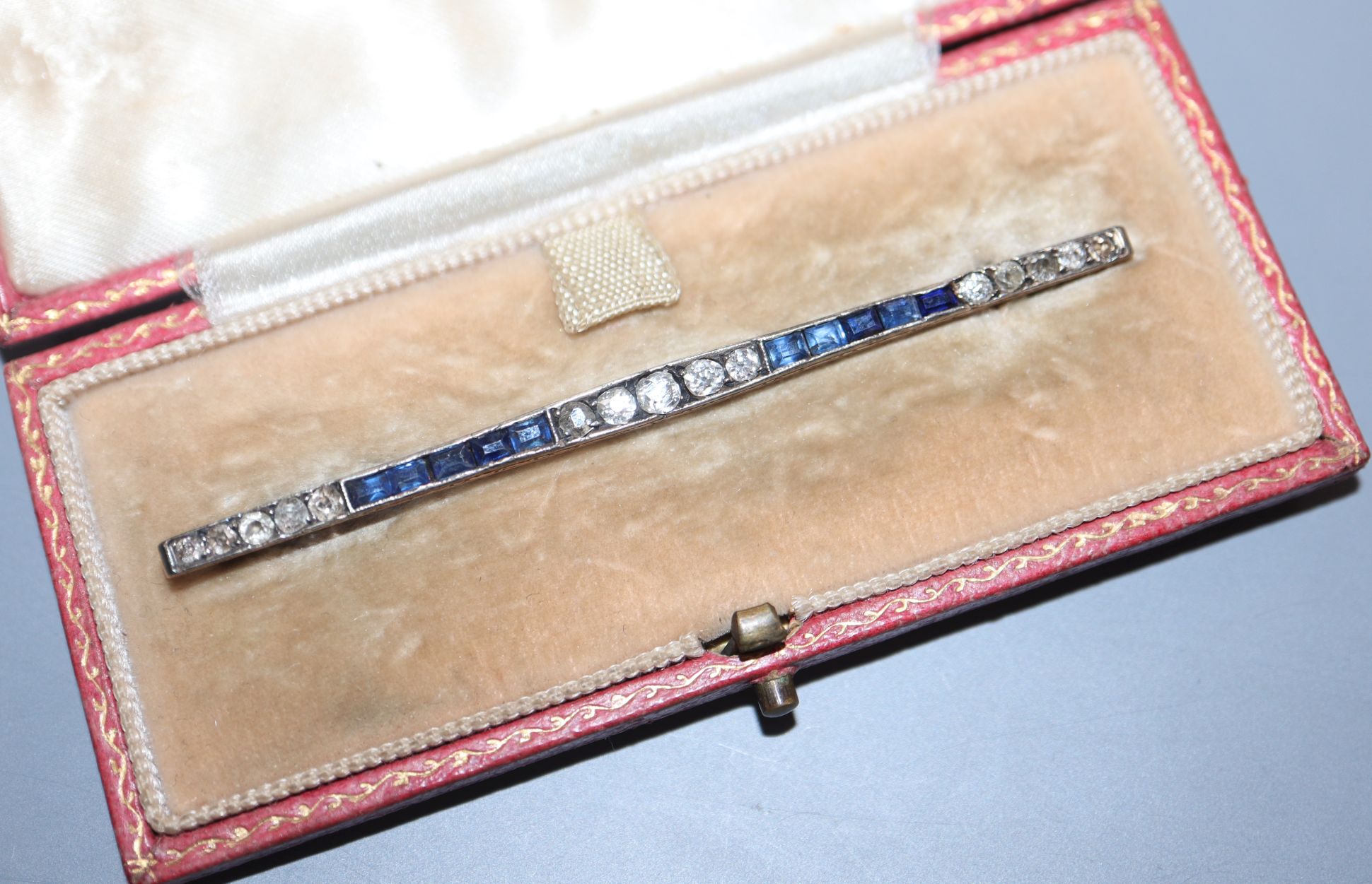 A 1920's yellow metal, sapphire and diamond set bar brooch, 71mm.