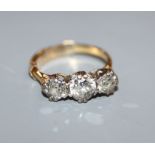 A yellow metal and three stone diamond ring, size H.