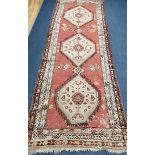 A Caucasian red ground runner 290 x 100cm