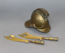 An early 20th century model brass fireman's helmet money box, two trench art paperknives and a shell