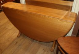 An Ercol light elm oval drop-leaf dining table, W.130cm