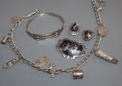 A silver charm bracelet, hung with nine charms including a Victorian locket, a 925 bangle and a