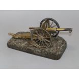 An early 20th century brass model cannon on cast bronze base
