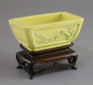 A Chinese yellow glazed biscuit model jardiniere, Qing dynasty, the sides carved in relief with