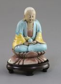 A Chinese enamelled biscuit seated figure of Buddha, 18th/19th century, with turquoise and yellow