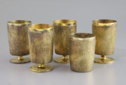 Adrian Gerald Benney. A set of four bark effect silver gilt goblets, on short stems and a similar