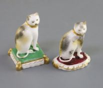 Two Rockingham porcelain figures of seated cats, c.1826-30, the first on a rococo base, impressed '