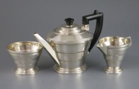 A George VI Art Deco silver three piece tea set, by A.L. Davenport Ltd, of banded tapering form,