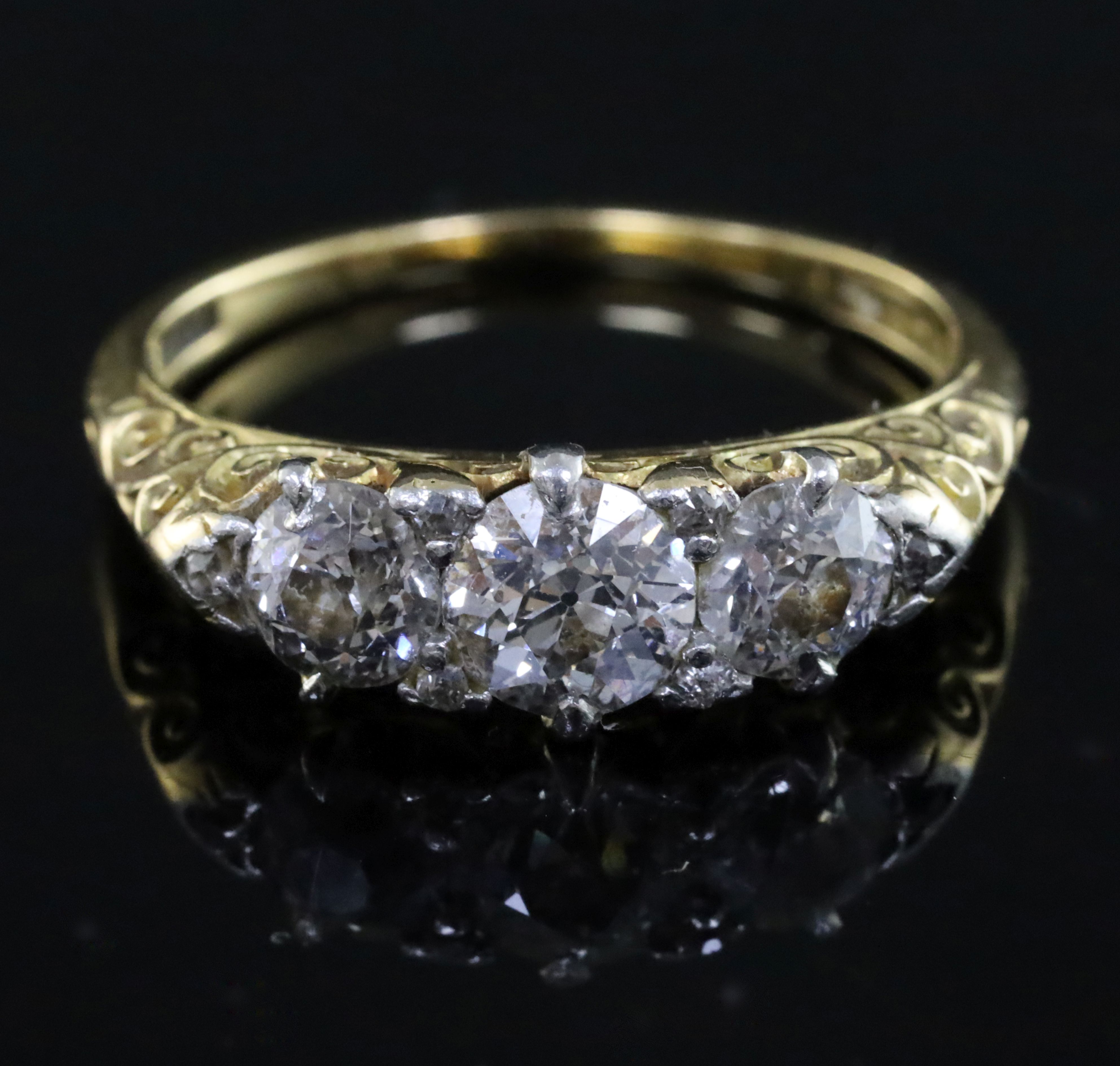 An Edwardian 18ct gold and graduated three stone diamond ring, with diamond chip spacers and