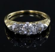 An Edwardian 18ct gold and graduated three stone diamond ring, with diamond chip spacers and