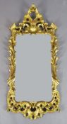 A George III giltwood wall mirror, with pierced scroll and flower frame, and later shaped