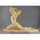 Lucien Alliot. An Art Deco carved stone figure of a naked female dancer, signed, length 28in. height