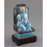 A Chinese turquoise and manganese glazed biscuit figure of Zhenwu, 17th century, seated on a