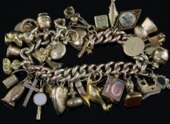 A 9ct gold charm bracelet, hung with thirty three assorted gold charms, gross 69.3 grams.