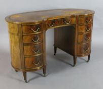 An Edwardian boxwood strung mahogany kidney shaped desk, with brown skiver and nine drawers, on